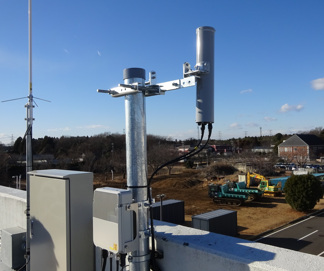 写真-1 屋外実験ヤード内へ向けられたNEC製ローカル5G基地局とアンテナ